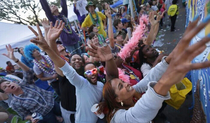 Los asistentes al desfile intentan atrapar los collares lanzados desde las carrozas durante el desfile del Krewe of Bacchus Mardi Gras en la avenida Napoleon de Nueva Orleans el 2 de marzo de 2014. (Gerald Herbert/Foto AP)