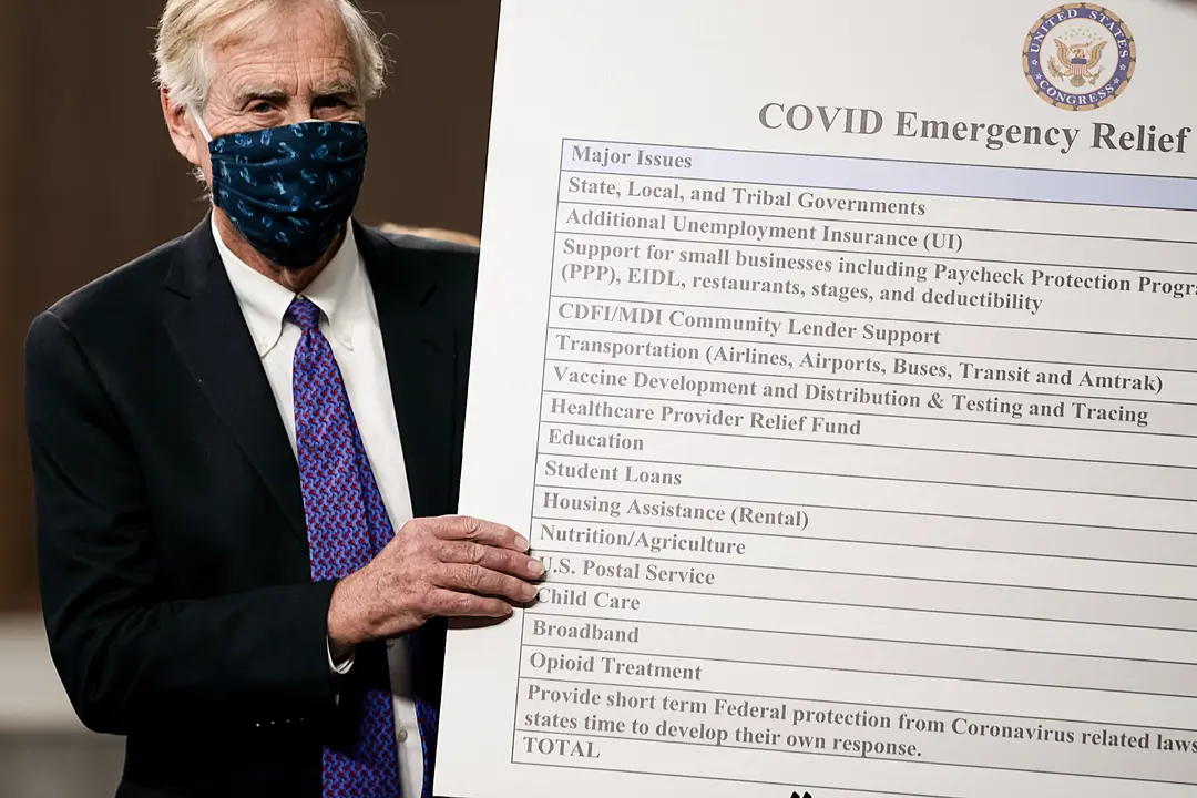 El senador Angus King (I-Maine) coloca un cartel junto a un grupo bipartidista de congresistas demócratas y republicanos mientras anuncian una propuesta de ley de ayuda por el COVID-19 en el Capitolio el 1 de diciembre de 2020. (Tasos Katopodis/Getty Images)