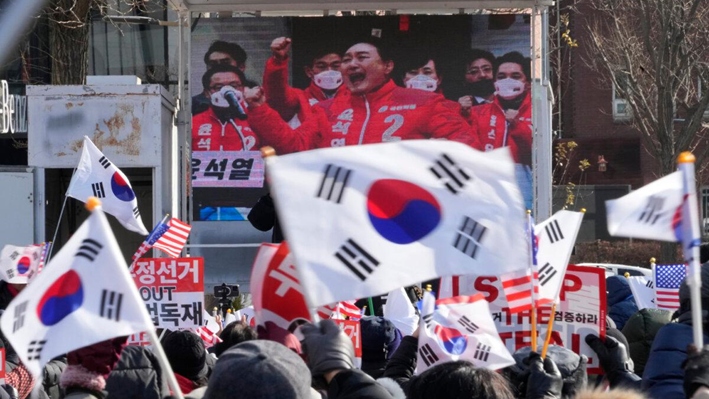 Una pantalla de televisión muestra una imagen de archivo del presidente surcoreano Yoon Suk Yeol mientras sus partidarios organizan una concentración para oponerse a su destitución, cerca de la residencia presidencial en Seúl, Corea del Sur, el 7 de enero de 2025. (Ahn Young-joon/AP)