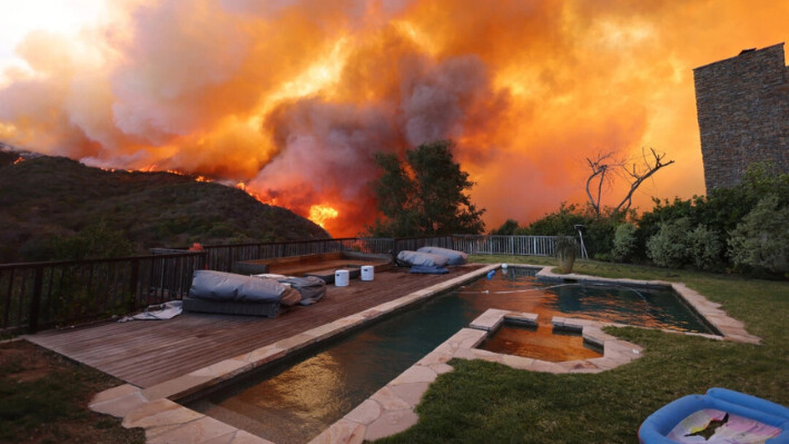 Un incendio de matorrales arde cerca de unas viviendas en Pacific Palisades, California, el 7 de enero de 2025. (David Swanson/AFP vía Getty Images).