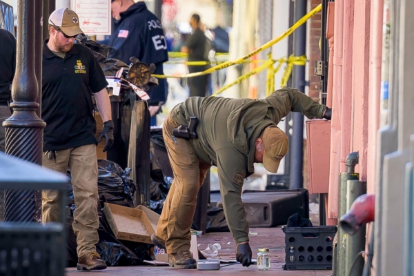 Un agente del FBI (izq.) y un agente de la Policía Estatal de Luisiana examinan un tarro de cristal durante la investigación en Bourbon Street el 1 de enero.(Matthew Hinton/AP)