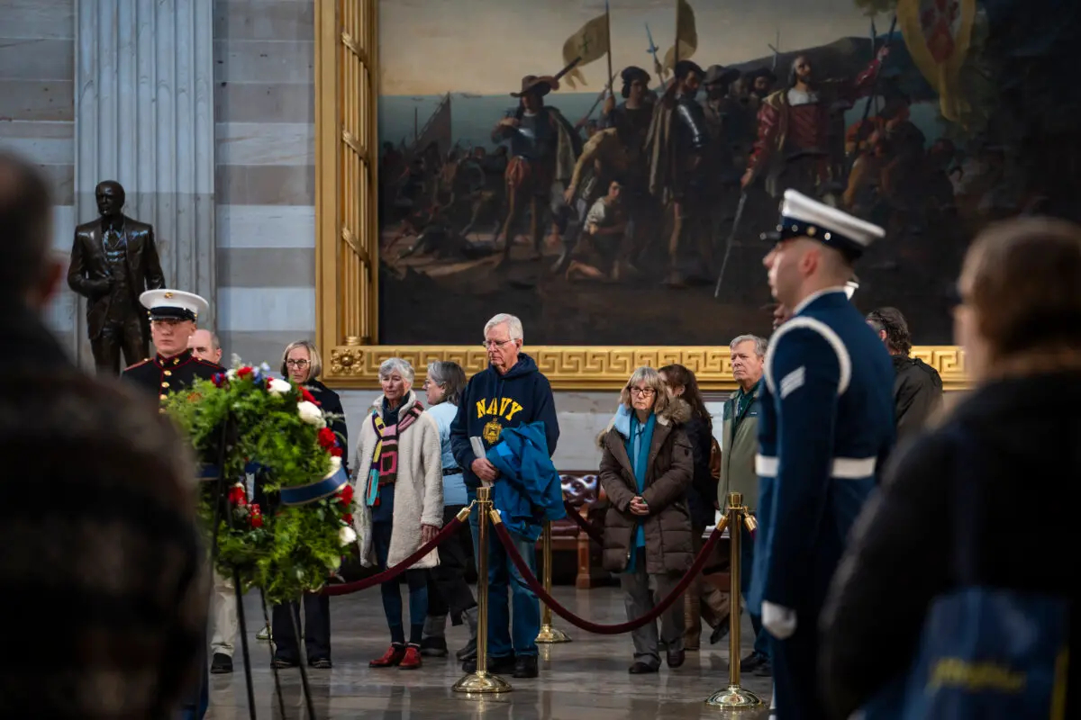 Un grupo de personas presenta sus respetos ante el féretro envuelto en una bandera del expresidente Jimmy Carter en la Rotonda del Capitolio de EE. UU. en Washington el 8 de enero de 2025. (Madalina Vasiliu/The Epoch Times)