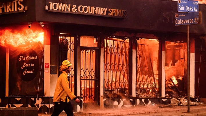 Un bombero pasa junto a una licorería en llamas durante el incendio de Eaton en el área de Altadena del condado de Los Ángeles, California, el 8 de enero de 2025. (Josh Edelson/AFP vía Getty Images)