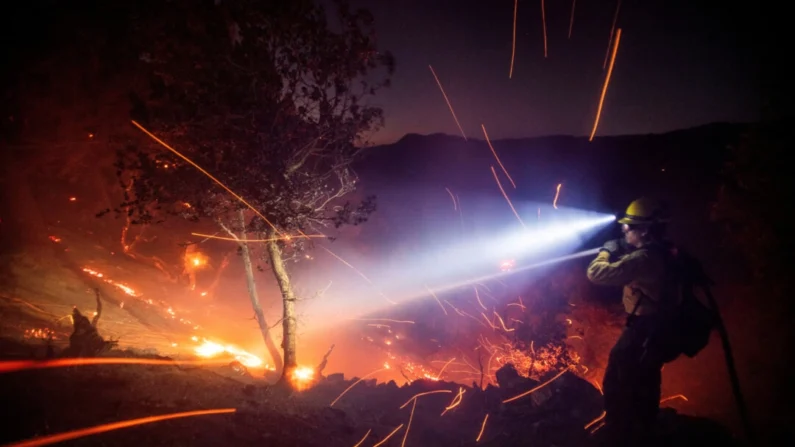 El viento sopla las brasas mientras un bombero combate el fuego en el Bosque Nacional de los Ángeles cerca del Monte Wilson, durante el incendio de Eaton en Altadena, California, el 9 de enero de 2025. (Ringo Chiu/Reuters)