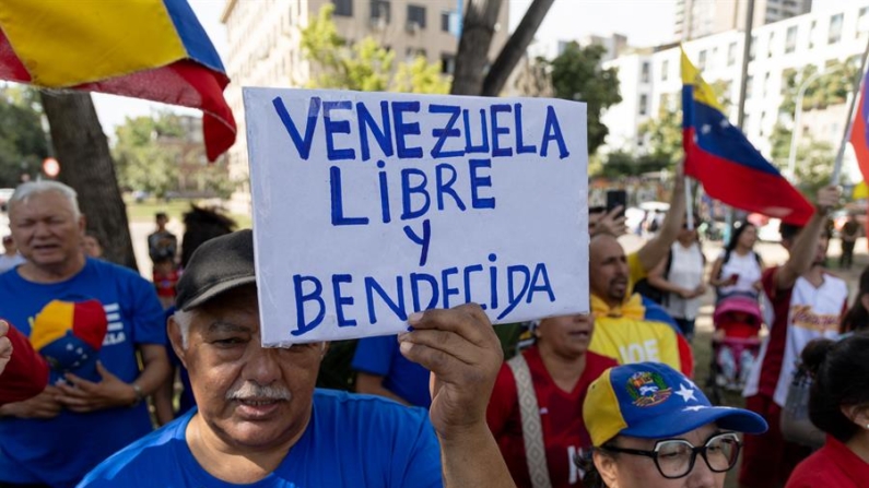 Un hombre sostiene un cartel durante una manifestación convocada por el Comando con Venezuela el 11 de enero de 2025 en Santiago (Chile). EFE/ Ailen Díaz