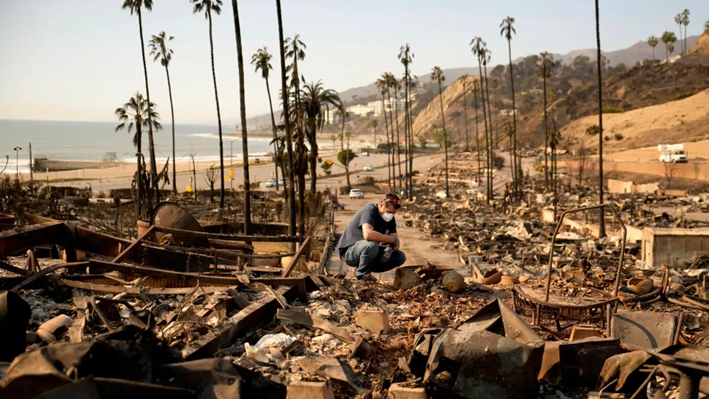 Kevin Marshall rebusca en la propiedad de su madre arrasada por el fuego en el incendio de Palisades, en el barrio de Pacific Palisades de Los Ángeles, el 11 de enero de 2025. (John Locher/AP Photo)