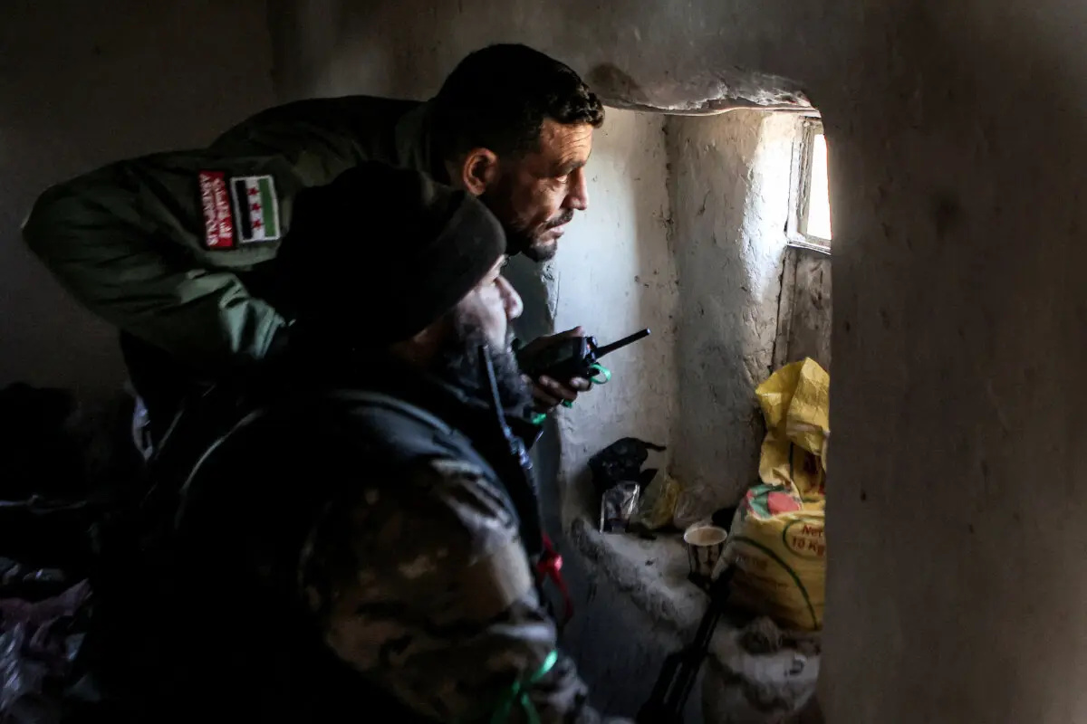 Combatientes de la facción del Ejército Nacional Sirio respaldada por Turquía observan desde una ventana en una casa en una posición cerca de la presa de Tishrin en las inmediaciones de Manbij, en el este de la provincia septentrional siria de Alepo, el 10 de enero de 2025. (Aaref Watad / AFP vía Getty Images)