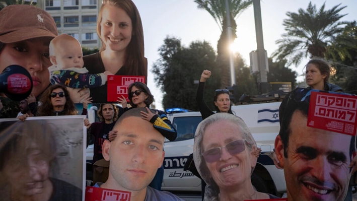 Familiares y simpatizantes de rehenes israelíes retenidos por Hamás en Gaza sostienen fotografías de sus seres queridos durante una protesta para pedir su regreso, en Tel Aviv, Israel, el 8 de enero de 2025. (AP Photo/Ohad Zwigenberg)