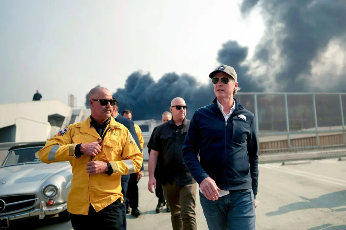 El gobernador de California, Gavin Newsom (d), recorre el distrito comercial de Pacific Palisades mientras el incendio de Palisades continúa ardiendo en Los Ángeles el 8 de enero de 2025. (Eric Thayer/Getty Images)