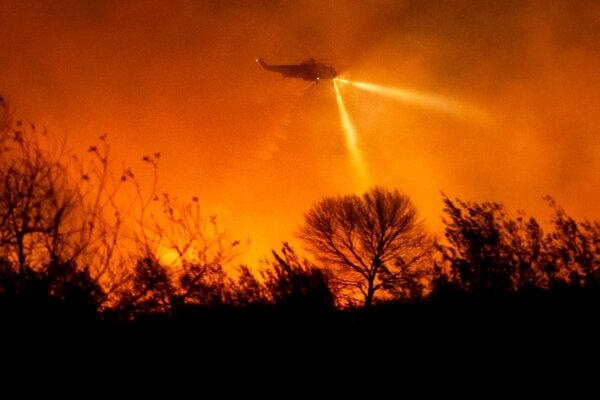 Un helicóptero lanza agua mientras lucha contra el incendio de Auto en el condado de Ventura, California, el 13 de enero de 2025. (Noah Berger/Foto AP)