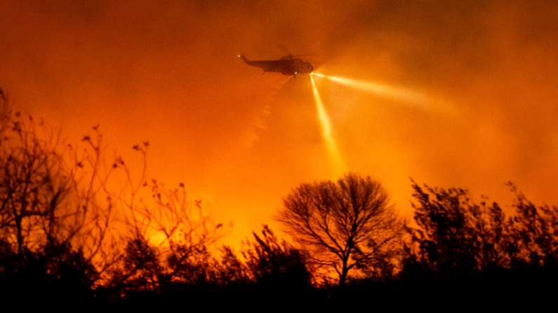 Un helicóptero lanza agua sobre el incendio Auto Fire en el condado de Ventura, California, el 13 de enero de 2025. (Noah Berger/Foto AP)