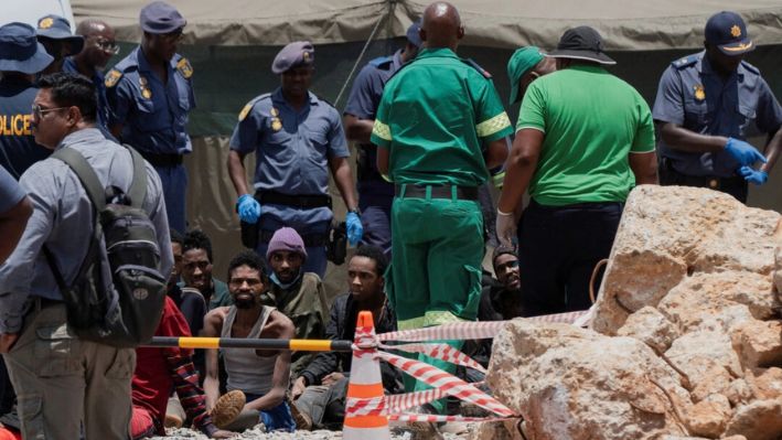 La policía procesa a unos mineros tras rescatarlos de un pozo de una mina en Stilfontein, Sudáfrica, el 14 de enero de 2025. (Ihsaan Haffejee/Reuters)
