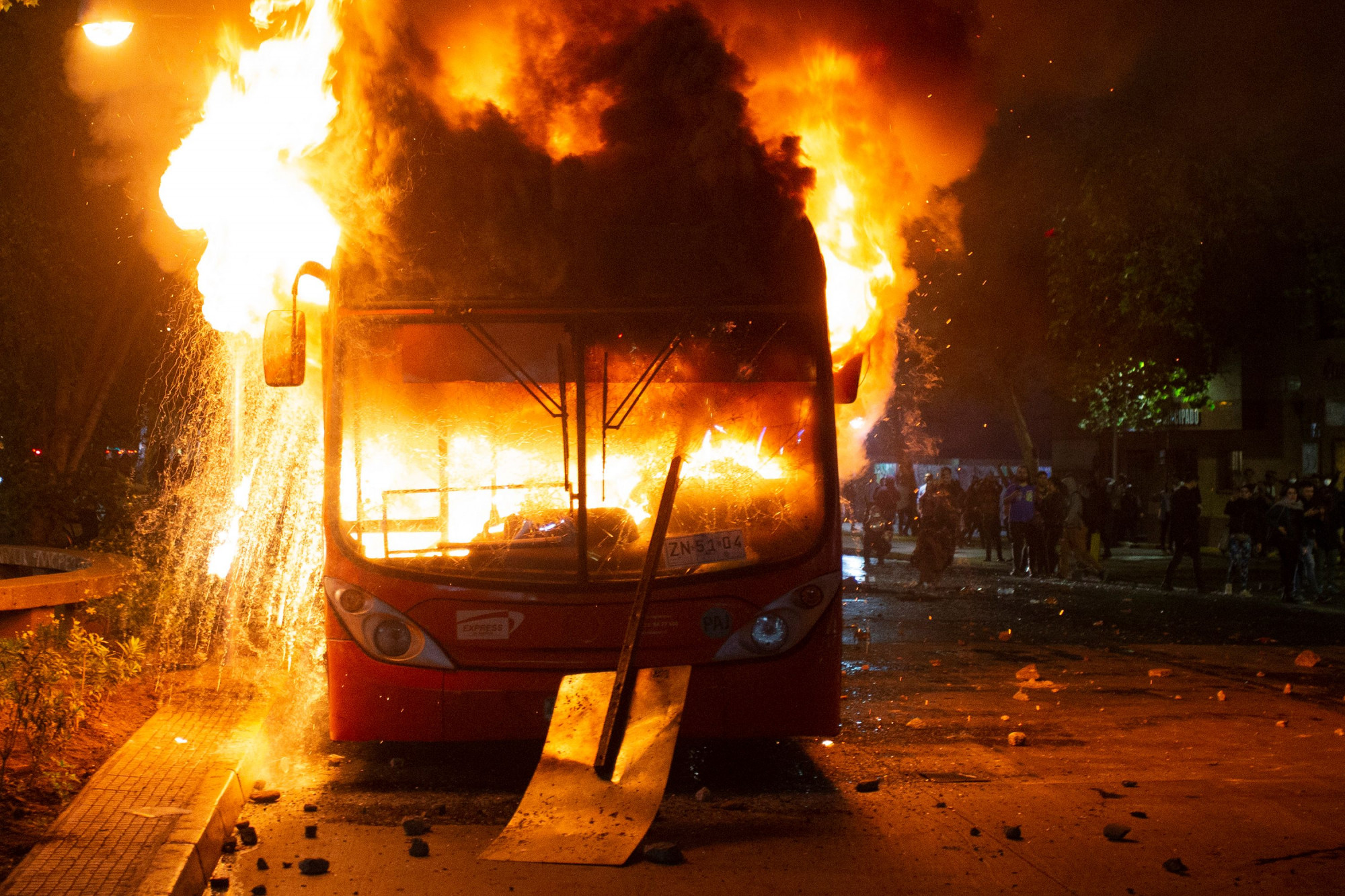 Um ônibus pega fogo no centro de Santiago, em 18 de outubro de 2019, após um protesto maciço de devido ao aumento das passagens (Claudio Reyes / AFP através da Getty Images)