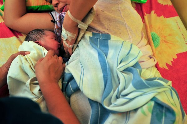 Um bebê recém-nascido é preparado e entregue à mãe momentos após o parto em uma sala de parto em 10 de maio de 2013 (Veejay Villafranca / Getty Images)