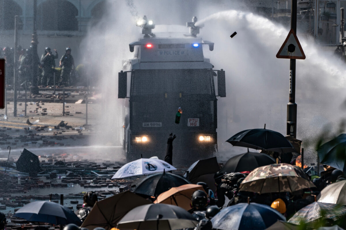  A polícia dispara um canhão de água de um veículo enquanto manifestantes lançam uma bomba contra a Universidade Poytechnic de Hong Kong em 17 de novembro de 2019 em Hong Kong (Anthony Kwan / Getty Images)