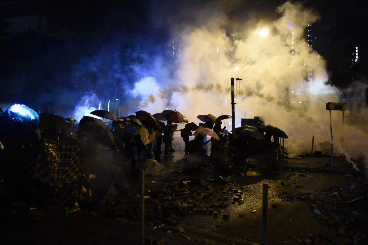 Manifestantes estão no meio do gás lacrimogêneo disparado pela polícia durante confrontos do lado de fora da Universidade Politécnica de Hong Kong, no distrito de Hung Hom, em 17 de novembro de 2019 (Ye Aung Thu / AFP via Getty Images)