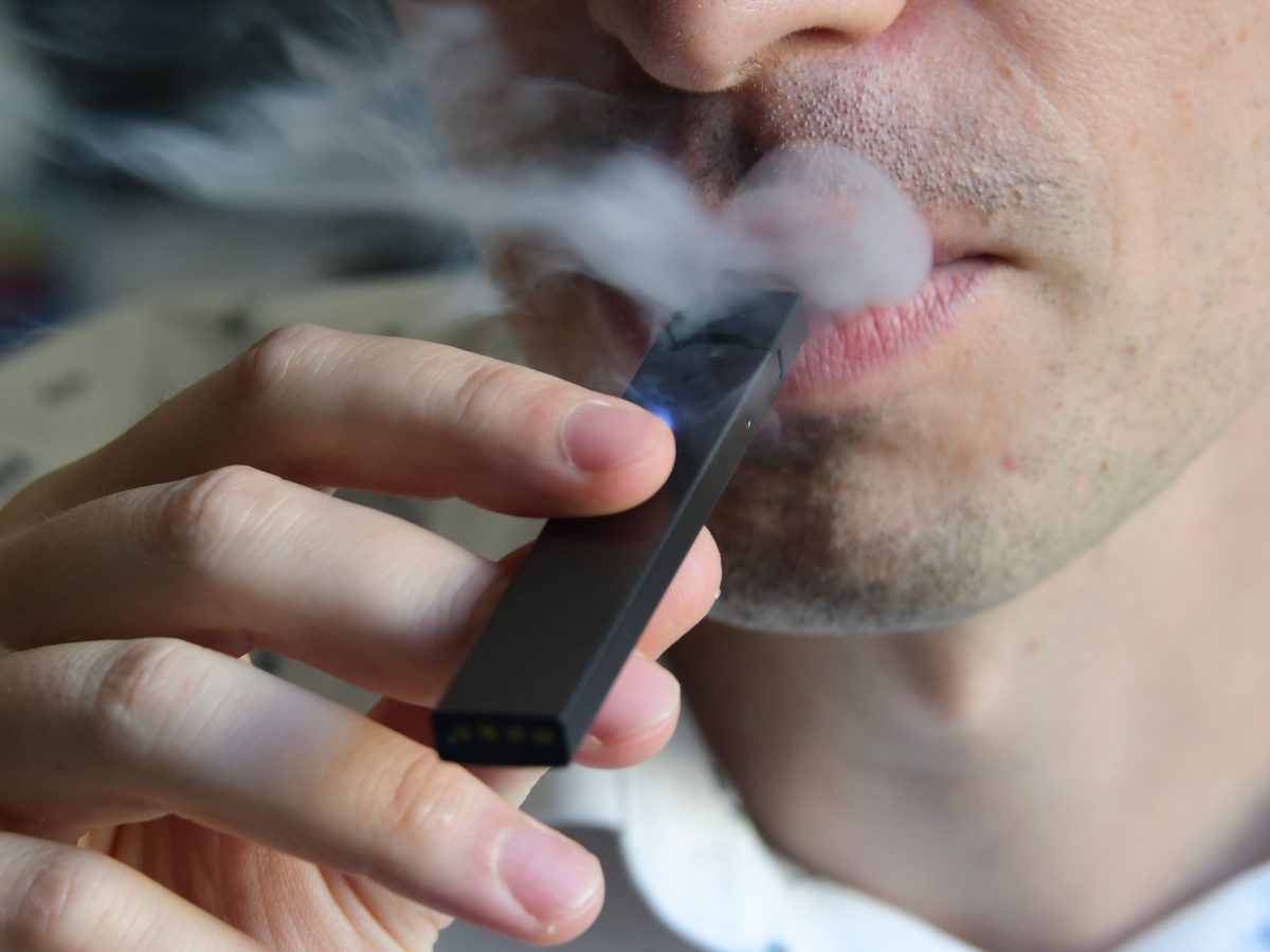 Uma ilustração mostra um homem exalando fumaça de um cigarro eletrônico (Eva Hambach / AFP / Getty Images)