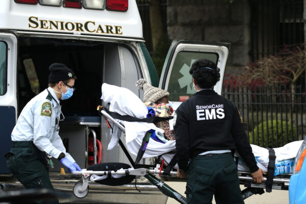 Trabajadores de emergencias médicas bajan a un paciente fuera de un hogar de ancianos, en Brooklyn, Nueva York, el 18 de abril de 2020. (Justin Heiman/Getty Images)