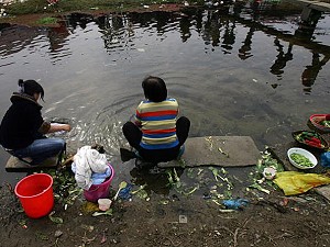 Villagers wash clothes and prepare food in a ditch on March 22, 2008, World Water Day, in Wuhan, a suburb of Hubei Province, China. China held various activities to mark the 16th World Water Day with the theme of this year 