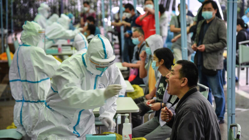 Un trabajador médico toma una muestra de hisopo de un residente para ser analizado por COVID-19 en Wuhan, China, el 14 de mayo de 2020. (STR/AFP vía Getty Images)