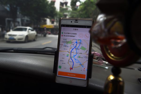 Un taxista utiliza la app Didi Chuxing mientras conduce por una calle de la ciudad de Guilin, en la provincia meridional china de Guangxi, el 13 de mayo de 2016. (Greg Baker/AFP/Getty Images)