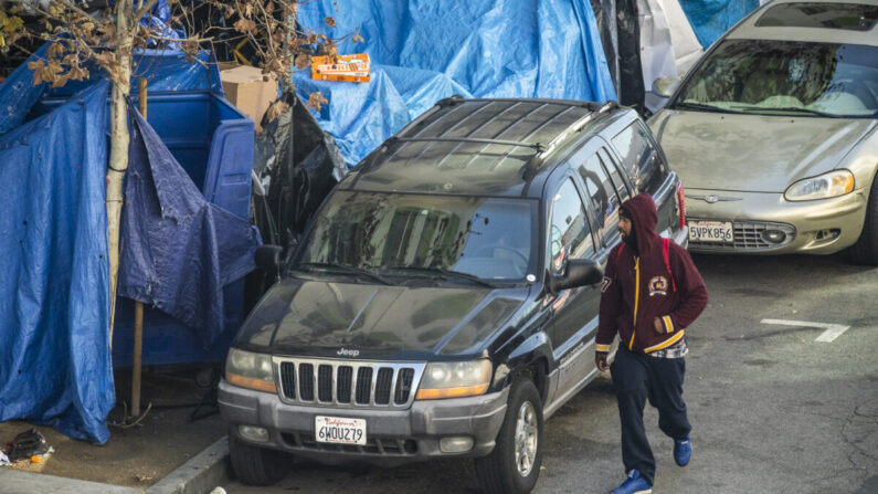 Un hombre pasa por delante de un campamento de personas sin hogar en Los Ángeles, California, el 6 de enero de 2022. (John Fredricks/The Epoch Times)