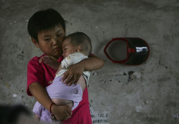 Wang Huaixue holds a baby at Wang Jiayu Orphanage on July 9, 2006 in Anhui Province. Millions of official and unofficial orphans are the victims of a Chinese social system. (China Photos/Getty Images)