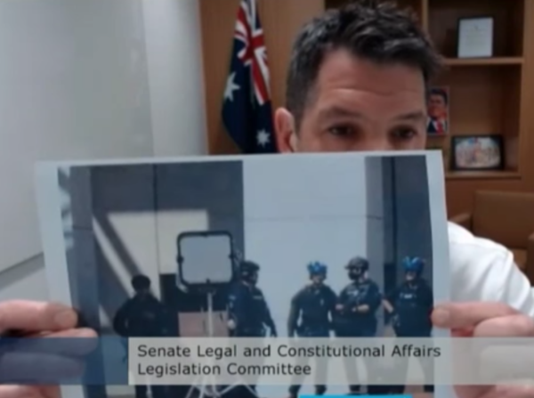 El senador australiano Alex Antic sostiene una imagen de un dispositivo acústico de largo alcance que circulaba por las redes sociales en una audiencia de estimaciones del Senado en Canberra, Australia, el 14 de febrero de 2022. (Captura de pantalla de The Epoch Times)