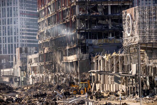 Los bomberos ucranianos trabajan entre los escombros del centro comercial Retroville, un día después de que las fuerzas rusas bombardearan un distrito residencial al noroeste de la capital ucraniana, Kiev, el 21 de marzo de 2022. (Fadel Senna/AFP a través de Getty Images)