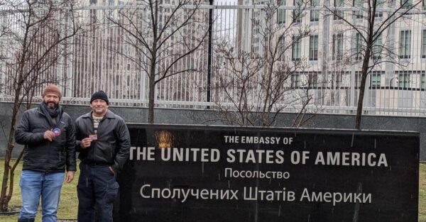 Bryan Stern, co-founder of Project Dynamo, stands in front of the sign for the now shuttered American embassy in Kiev, Ukraine, following the start of Russia