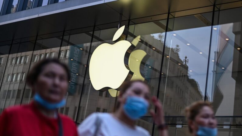 Personas con mascarillas pasan por delante de una tienda de Apple en Shanghái el 2 de junio de 2020. (Hector Retamal/AFP vía Getty Images)
