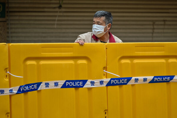 Un hombre permanece detrás de las barreras durante el bloqueo en el distrito de Jing'an, en Shanghai, el 31 de marzo de 2022. (Hector Retamal/AFP vía Getty Images)