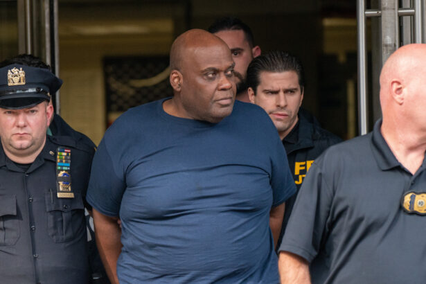 El sospechoso Frank James es escoltado por la policía a la salida de la 9° comisaría tras ser detenido por el tiroteo masivo en la estación de metro de la calle 36, en Nueva York, el 13 de abril de 2022. (David Dee Delgado/Getty Images)
