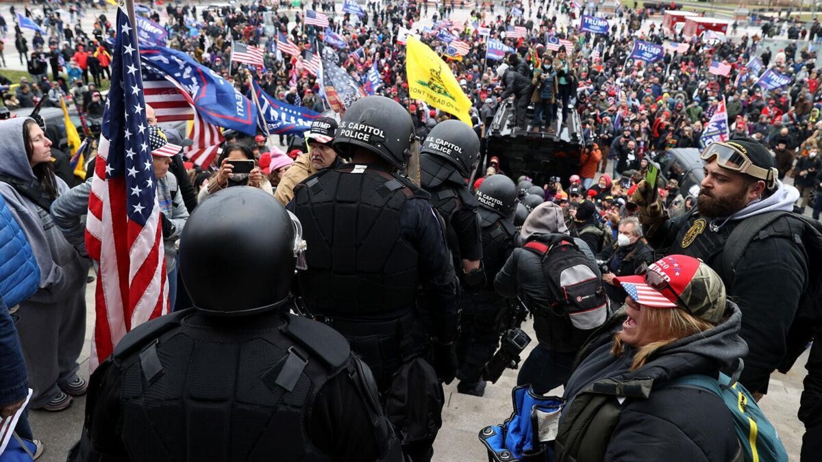 Photo showing Capitol Police being escorted down the Capitol steps through the crowd to safety on January 6 by members of the Oath Keepers.