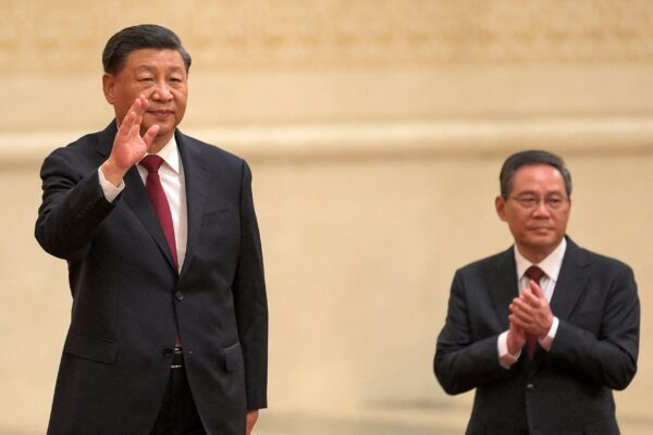 El líder chino Xi Jinping (izq.) saluda a Li Qiang (der.), miembro del nuevo Comité Permanente del Politburó del Partido Comunista Chino, mientras se reúnen con los medios de comunicación en el Gran Salón del Pueblo en Beijing el 23 de octubre de 2022. (Wang Zhao/AFP vía Getty Images)
