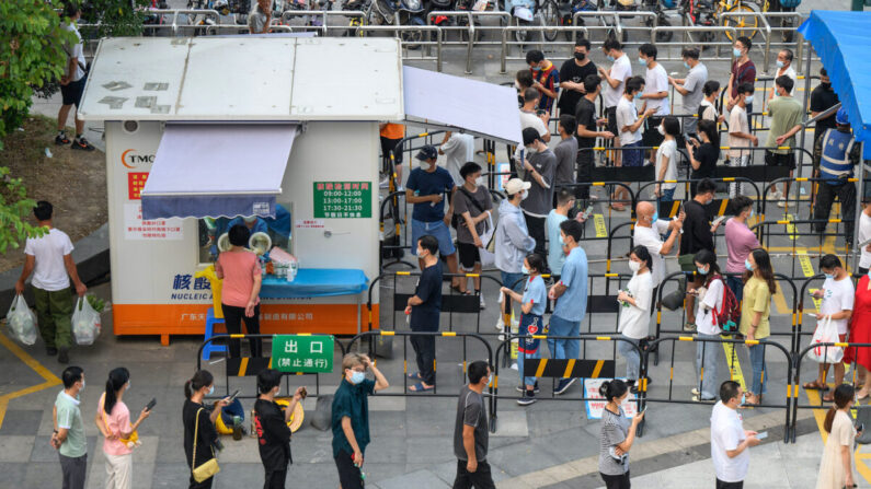 Los residentes esperan en fila para someterse a la prueba de PCR para COVID-19 en un sitio de recolección de muestras en Guangzhou, en la provincia de Guangdong, al sur de China, en agosto de 2022. (STR/AFP vía Getty Images)
