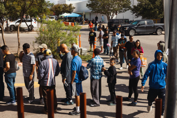 Grupos de inmigrantes ilegales solicitantes de asilo esperan fuera del Centro de Recursos para Migrantes para recibir alimentos de las Caridades Católicas de San Antonio en San Antonio, Texas, el 19 de septiembre de 2022. (Jordan Vonderhaar/Getty Images)
