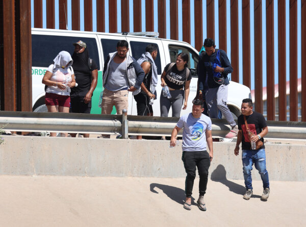 Ciudadanos venezolanos caminan a lo largo de la valla fronteriza hacia una camioneta de la Patrulla Fronteriza que los espera después de cruzar ilegalmente el Río Grande desde México, en El Paso, Texas, el 21 de septiembre de 2022. (Joe Raedle/Getty Images)
