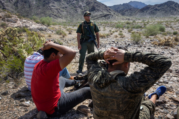 Un agente de la Patrulla Fronteriza de Estados Unidos vigila a un grupo de inmigrantes ilegales después de rastrearlos a través de un terreno accidentado en el Monumento Nacional Organ Pipe, Arizona, el 28 de septiembre de 2022. (John Moore/Getty Images)
