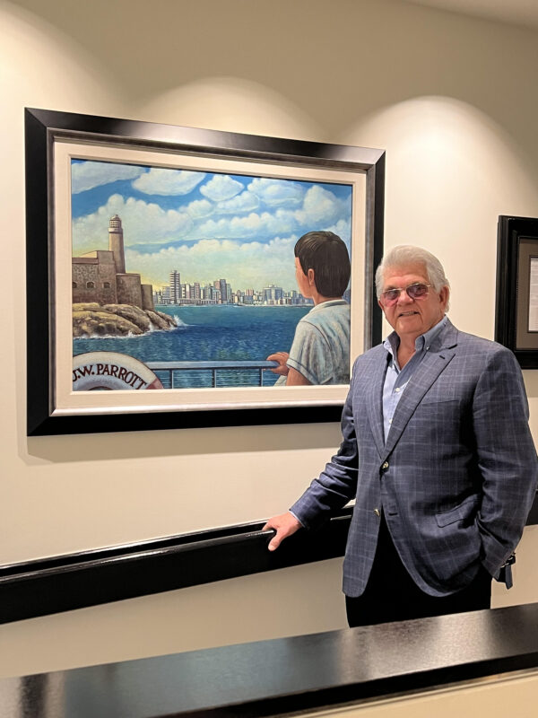 Maximo Alvarez stands before a painting done by a Cuban artist of depicting him fleeing Havana on the last cargo ship leaving Cuba on July 4, 1961. 