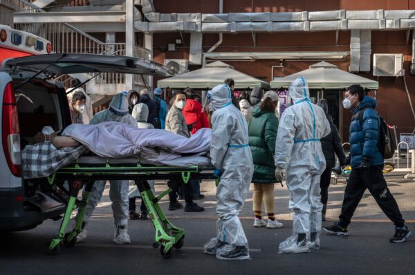 Trabajadores médicos usan EPP mientras llegan con un paciente en una camilla a una clínica de fiebre en Beijing, China, el 9 de diciembre de 2022. (Kevin Frayer/Getty Images)
