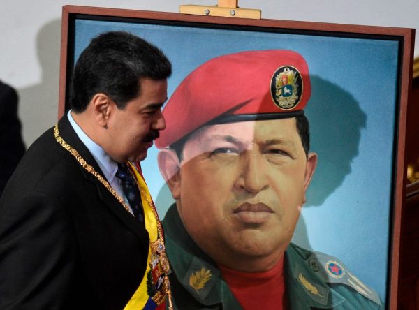 El líder venezolano Nicolás Maduro pasa junto a un retrato del fallecido líder venezolano Hugo Chávez en Caracas, el 14 de enero de 2019. (Federico Parra/AFP/Getty Images)
