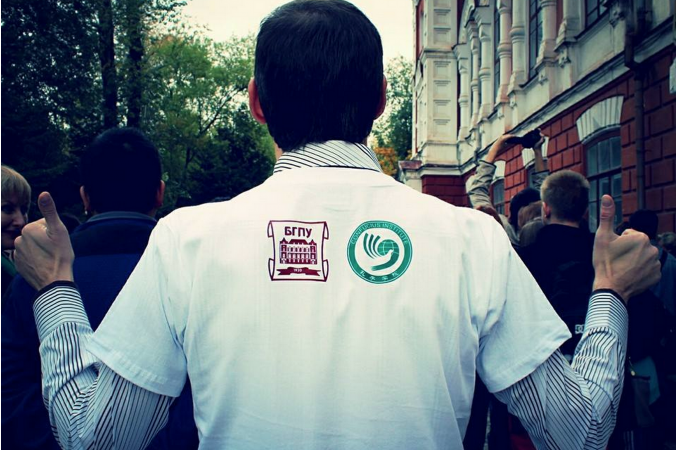 Un hombre viste una camiseta con los logos de la Universidad Pedagógica Estatal Blagoveshchensk y del Instituto Confucio; foto sin fecha. (Screen shot/Sinocenter.ru)