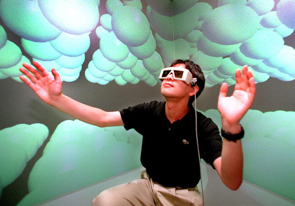 Un investigador del laboratorio de modelado inteligente de la Universidad de Tokio con unas gafas 3D, extiende su mano para tocar cómo se siente en el mundo microscópico en la sala de realidad virtual de un laboratorio. (Foto: YOSHIKAZU TSUNO/AFP/Getty Images)