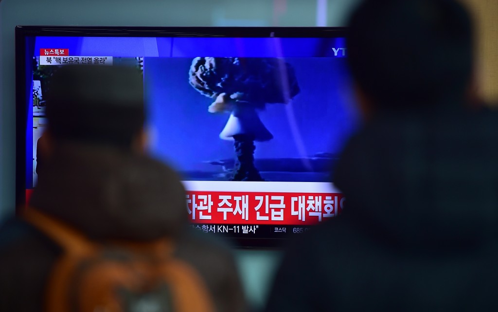 La gente ve un informativo de prueba de la bomba primera hidrógeno de Corea del Norte en una estación de ferrocarril en Seúl el 6 de enero de 2016. Corea del Sur 'fuertemente' condenado prueba de choque de la bomba de hidrógeno de Corea del Norte y prometió tomar "todas las medidas necesarias" para penalizar su nucleares vecino armado. La imagen se muestra en la televisión muestra imágenes de archivos de otras pruebas nucleares de otros países y la leyenda en rojo en la parte inferior de la pantalla se lee 'la Casa Azul será convocar una reunión de emergencia del Consejo de Seguridad Nacional, el Consejo Nacional de Seguridad.' (Photo credit should read JUNG Yeon-JE / AFP / Getty Images)