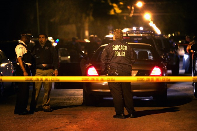 La policía investiga la escena en la que un niño de 15 años, fue muerto a tiros por la policía después de que  apuntó con un arma a los oficiales durante una persecución a pie en Chicago, Ill . , El 17 de junio de 2013. (Scott Olson / Getty Images)