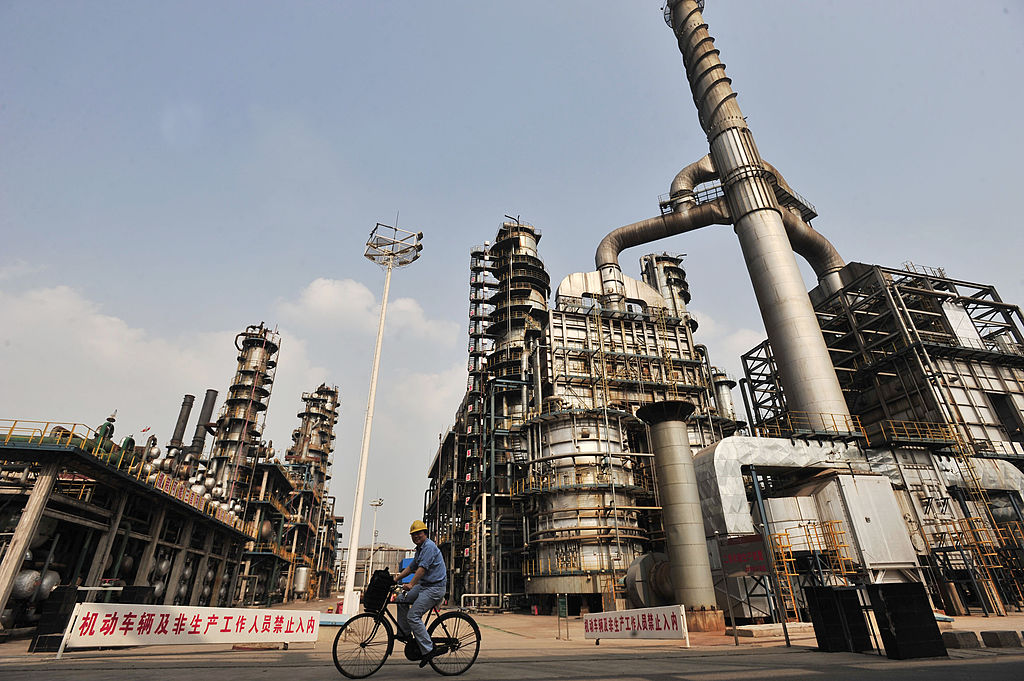 Un trabajador monta la bicicleta en una refinería de petróleo de Sinopec de China en Wuhan , una ciudad en la provincia de Hubei de China el 10 de mayo, 2011. ( STR / AFP / imágenes Getty)
