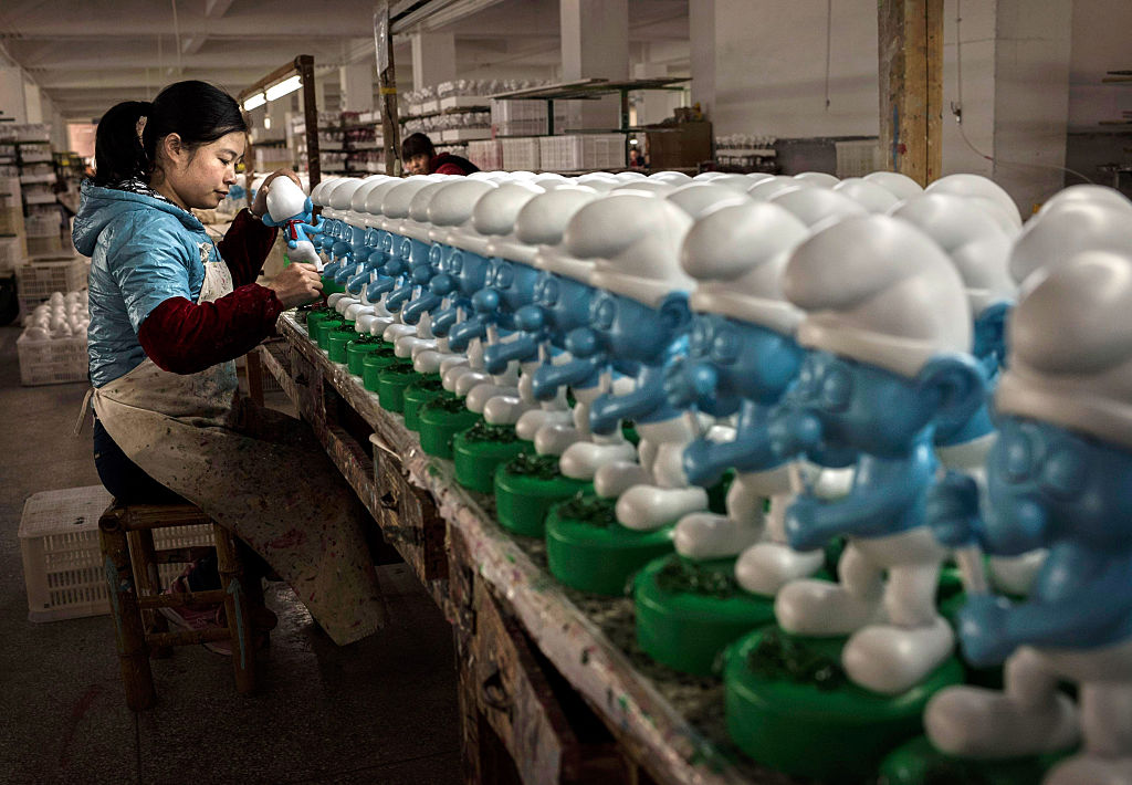 Una trabajadora china pinta cerámica de 'Pitufos' en la fábrica Shunmei Group (SMG) el 7 de diciembre de 2014 en Dehua, provincia de Fujian, China. (Foto por Kevin Frayer / Getty Images)