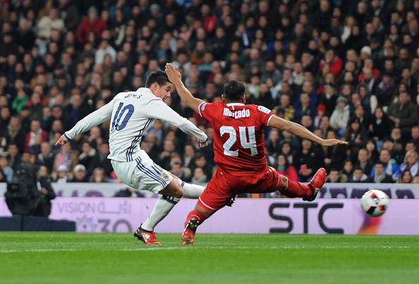 MADRID, SPAIN - JANUARY 04: James Rodriguez of Real Madrid shoots past Gabriel Mercado of Sevilla FC to score Real's opening goal during the Copa del Rey Round of 16 First Leg match between Real Madrid and Sevilla at Bernabeu on January 4, 2017 in Madrid, Spain. (Photo by Denis Doyle/Getty Images)