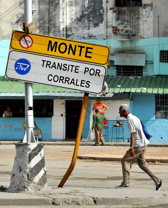 Un hombre camina frente a una señal de tránsito destruida en Havana el 11 de enero de 2016. (YAMIL LAGE/AFP/Getty Images)